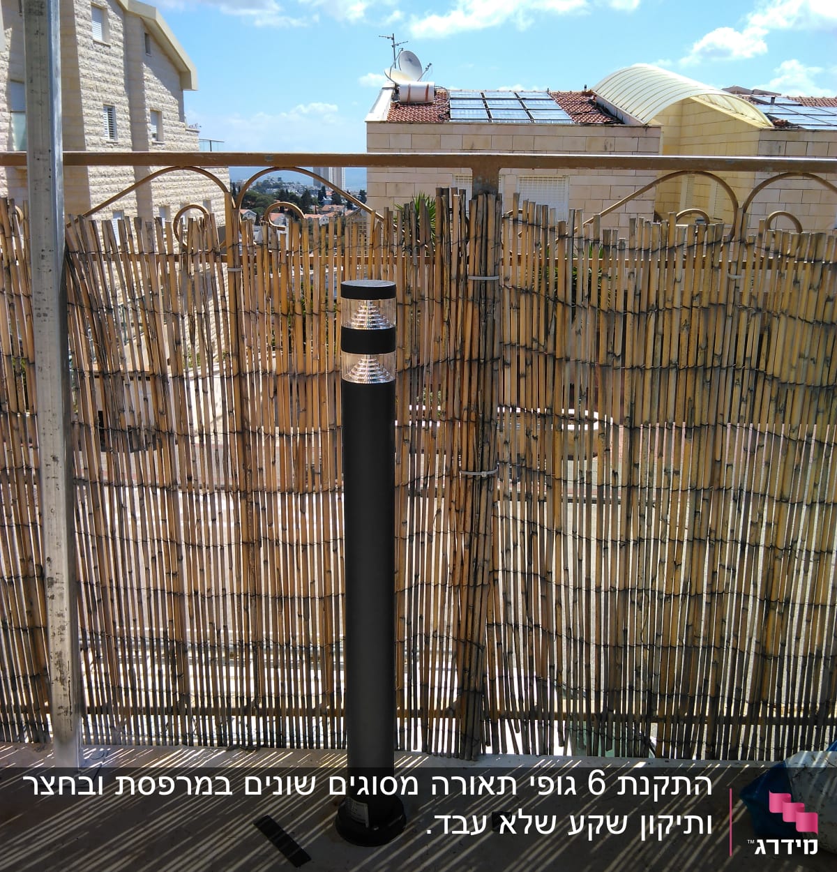 עמוד תאורה שחור מותקן על קיר אבן